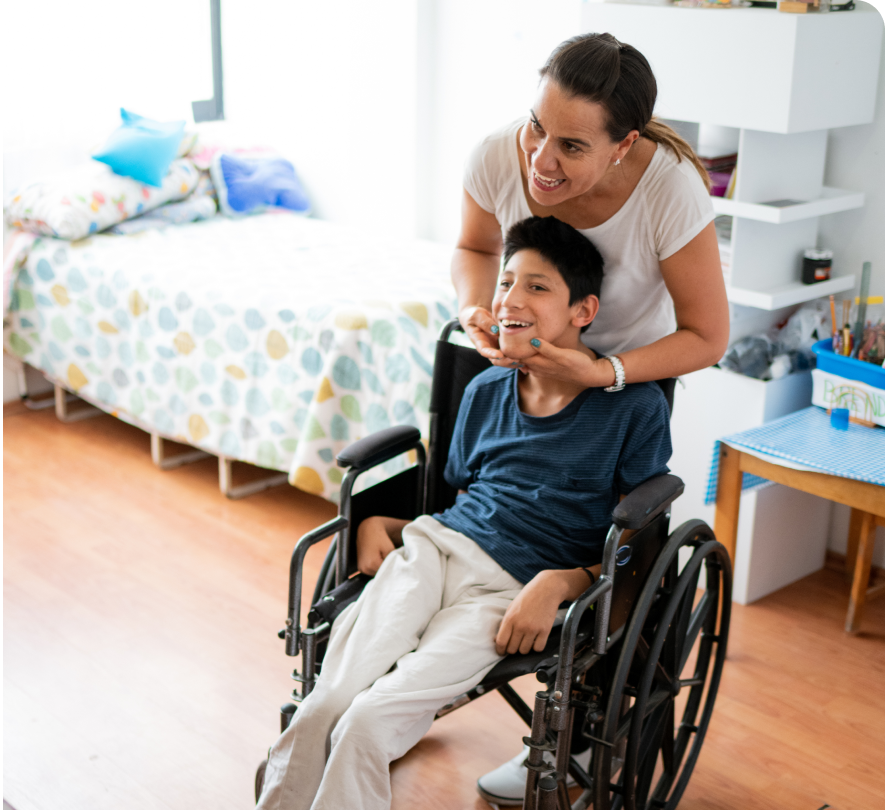 Smiling caregiver with child in wheelchair